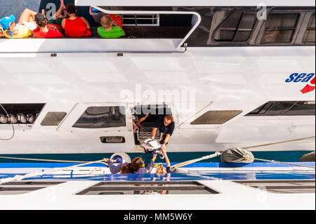 Passagers et produits sont transférés d'un bateau de plongée à un autre milieu de l'océan au-dessus de la Grande Barrière de Corail, Queensland, Australie. Banque D'Images