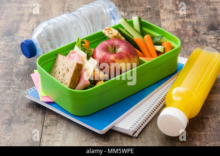 École en santé boîte à lunch : sandwich, fruits et jus de légumes ,on wooden table Banque D'Images