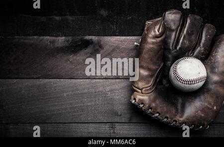 Un groupe d'équipement baseball vintage, les chauves-souris, des gants de baseball, sur fond de bois Banque D'Images
