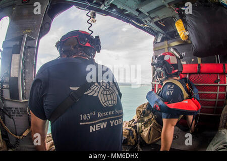 Pararescuemen donnent à la vue de dessus de l'eau sur le chemin de Saint Thomas. Aviateurs de la New York Air National Guard's 106th Rescue Wing voler plus de Saint-Thomas et Saint-John dans un HH-60 Pave Hawk helicopter le 10 septembre, 2017. Ils cherchent des personnes qui ont besoin d'une aide indispensable à la suite de l'ouragan l'Irma. Banque D'Images