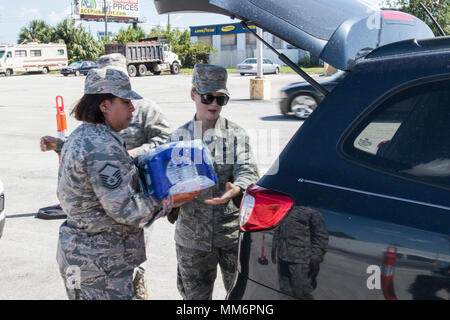 Le sergent-chef. Janine Obando et Senior Airman Caitlin la liberté, se trouvaient à bord de la 125e Escadre de chasse de la Garde nationale aérienne, la Floride, la main sur les cas de l'eau pour Floridiens touchés par l'ouragan l'Irma, le 13 septembre 2017. Des soldats et des aviateurs de la Garde nationale de Floride ont été déployés avec l'aide à la mise en place de points de distribution (POD) dans tout l'état. Banque D'Images