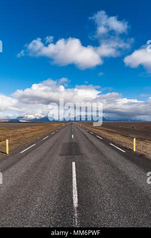 Le sud de l'Islande. La rocade vide (Route 1 ou Hringvegur) à Skaftafell et vers les montagnes enneigées de la Parc national du Vatnajökull Banque D'Images