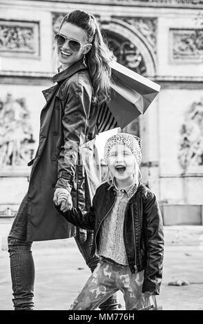 Automne élégant à Paris. smiling trendy la mère et l'enfant avec les sacs près de l'Arc de Triomphe à Paris, France Banque D'Images