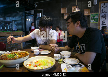 (180510) --, de BEICHUAN le 10 mai 2018 (Xinhua) -- Zheng Haiyang (L), un survivant qui a perdu ses jambes dans l'ampleur de 8.0 à 2008, suite au séisme de Wenchuan a un repas avec son ami dans un restaurant dans le nouveau comté de Beichuan, le sud-ouest de la province chinoise du Sichuan, le 8 mai 2018. Il y a dix ans, Zheng, 17 ans, étudiant à l'École de Beichuan, a dégagé 22 heures après qu'il a été pris au piège dans les décombres du bâtiment de l'école dans le comté de Beichuan. A Beichuan l'un des plus durement touchés lorsque le séisme a frappé le Sichuan catastrophique du comté de Wenchuan le 12 mai 2008. Zheng était un survivant de l'earthqu Banque D'Images