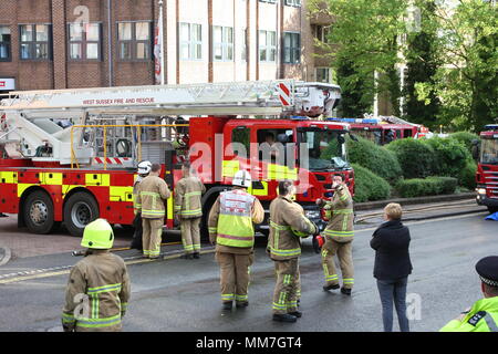 Haywards Heath, dans le Sussex, UK. 10 mai 2018. Les travailleurs d'urgence dans l'avant-cour de l'immeuble affectées par le feu . Plusieurs unités du service des incendies et police fermer Arklow Bay Orchard Bed and Breakfast Road à Haywards Heath, répondant à un incendie dans un grand immeuble de bureaux. Credit : Roland Ravenhill/Alamy Live News Banque D'Images