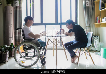 (180510) --, de BEICHUAN le 10 mai 2018 (Xinhua) -- Zheng Haiyang (L), un survivant qui a perdu ses jambes dans le 8.0-magnitude 2008 séisme de Wenchuan, discute avec son ami à la maison dans le nouveau comté de Beichuan, le sud-ouest de la province chinoise du Sichuan, le 8 mai 2018. Il y a dix ans, Zheng, 17 ans, étudiant à l'École de Beichuan, a dégagé 22 heures après qu'il a été pris au piège dans les décombres du bâtiment de l'école dans le comté de Beichuan. A Beichuan l'un des plus durement touchés lorsque le séisme a frappé le Sichuan catastrophique du comté de Wenchuan le 12 mai 2008. Zheng a été un survivant du tremblement de terre qui a laissé Banque D'Images