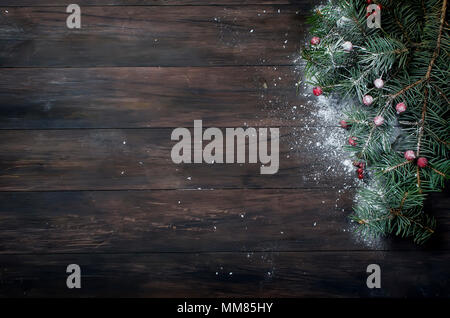 Fond hristmas avec arbre de Noël, fruits rouges sur fond de bois sombre. Joyeux Noël carte de souhaits, cadre. Thème des vacances d'hiver. Bonne Année. Banque D'Images