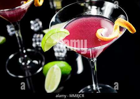 Boire de l'alcool cocktail Cosmopolitan avec de la chaux sur fond noir Banque D'Images