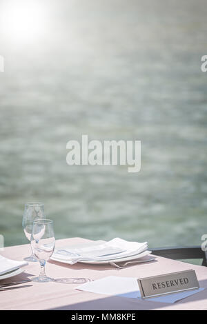 Verres vides sur une table de restaurant en plein air réservée dans une station balnéaire Banque D'Images