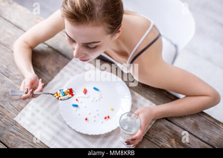 Vue de dessus du triste jeune femme assise à la table Banque D'Images