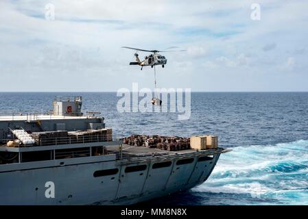 170913-N-SZ865-166 MER DES CARAÏBES (sept. 13, 2017) UN MH-60 transferts Sea Hawk de l'offre en soutien au combat rapide navire USNS Supply (T-AOE 6) à l'assaut amphibie USS Kearsarge LHD (3) au cours d'un ravitaillement en mer. Kearsarge participe à des efforts de secours à la suite du cyclone Irma. Le ministère de la Défense soutient l'Agence fédérale de gestion des urgences, le principal organisme fédéral, en aidant les personnes touchées par l'Ouragan Irma afin de minimiser la souffrance et est une composante de l'ensemble de l'intervention. (U.S. Photo par marine Spécialiste de la communication de masse Banque D'Images