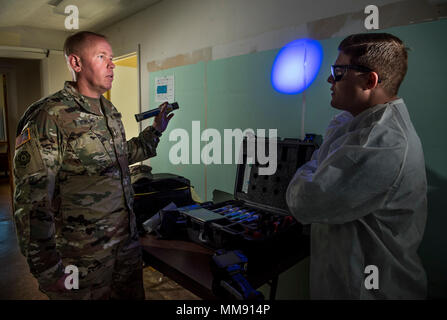 Agent spécial Ronald Bowling, un adjudant à la 383e détachement de police militaire (Commande d'enquête criminelle), de Lakeland, Floride, pose avec une lumière bleue sur une mise en scène judiciaire criminalité mur de scène avec l'agent spécial Jeremy Taylor, de la Washington CID bataillon, à Fort Belvoir, Virginie, au cours de la protection du capital dans le cadre d'une séance de photos destinées à promouvoir et à recruter des sous-officiers dans le domaine de carrière CID pour l'armée américaine, le 7 septembre 2017. L'agent spécial CID sous-officiers sont des chefs et des officiers qui gèrent tous les aspects de l'enquête criminelle crime dans toutes les activités Banque D'Images