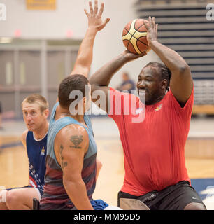 Vétéran du Corps des marines Matthieu Grashen tente de bloquer une passe par le vétéran de l'armée que les Etats-Unis Pone Anthony équipe de basket-ball en fauteuil roulant des trains pour l'Invictus Jeux à l'Université Hofstra, à New York, le 19 septembre 2017. À gauche est le capitaine de l'Armée de l'Air Cal Gentry. L'Invictus Games, établi par le prince Harry en 2014, rassemble des blessés et les anciens combattants blessés de 17 nations pour 12 événements sportifs adaptative, y compris l'athlétisme, le basket-ball en fauteuil roulant, rugby en fauteuil roulant, la natation, le volleyball assis, et nouveaux pour le jeux 2017, golf. (DoD photo par Roger L. Wollenberg) Banque D'Images