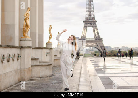 Belle femme marche sur la place du Trocadéro près de statues dorées et Tour Eiffel. Banque D'Images