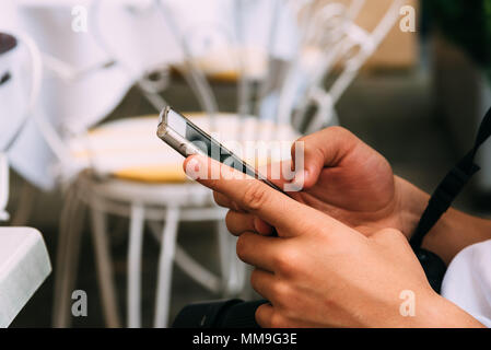 Close up of young adult texting on smartphone. Banque D'Images
