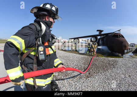 Un 72e Escadron de génie civile tend une main rouge pompier-flexible pendant un événement de formation à l'incendie de l'avion de taille de l'appareil de formation situé sur l'aérodrome le 13 septembre 2017, Tinker Air Force Base, Texas. Les pompiers de Tinker AFB ont été rejoints par des membres de l'aéroport international de Tulsa pompiers au cours de recertification annuelle de formation. (U.S. Air Force photo/Greg L. Davis) Banque D'Images