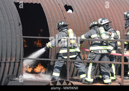 Les membres du 72e Escadron de génie civile, pompiers, travailler ensemble pour combattre un incendie près de la porte d'entrée de l'appareil de formation les incendies d'aéronefs, du 13 septembre 2017, Tinker Air Force Base, Texas. Les pompiers ont pris chacun tourne dans la porte afin de confirmer le bon fonctionnement technique de l'incendie pour la situation au cours de recertification annuelle de formation. (U.S. Air Force photo/Greg L. Davis) Banque D'Images