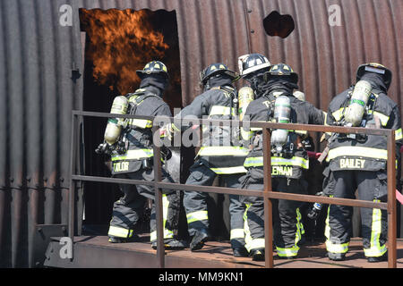 Les membres du 72e Escadron de génie civile, pompiers, travailler ensemble pour combattre un incendie près de la porte d'entrée de l'appareil de formation les incendies d'aéronefs, du 13 septembre 2017, Tinker Air Force Base, Texas. Les pompiers ont pris chacun tourne dans la porte afin de confirmer le bon fonctionnement technique de l'incendie pour la situation au cours de recertification annuelle de formation. (U.S. Air Force photo/Greg L. Davis) Banque D'Images