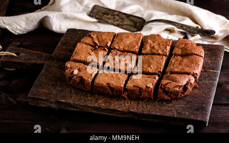 Brownie au chocolat rectangulaire cuit la tarte soit couper en carrés sur une planche à découper cuisine brun, vue du dessus Banque D'Images