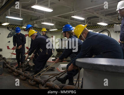 170921-N-OE873-1044 SAN DIEGO (sept. 21, 2017) Les marins affectés au navire d'assaut amphibie USS Makin Island (DG 8) déplacer l'ancre tribord au cours de la chaîne d'une chaîne à décharger dans le gaillard. Makin Island est actuellement en cale sèche à General Dynamics et de l'Acier National Shipbuilding Company (NASSCO) pour un dépôt d'entretien au niveau de disponibilité. (U.S. Photo par marine Spécialiste de la communication de masse 3 Classe Asher Allen) Banque D'Images