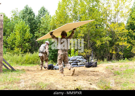 Le Sgt. Josué 1ère classe Tygret, attribué à 744th Ordnance Disposal Company, 52e Groupe des explosifs et munitions, utilise des matériaux récupérés à partir de la zone à protéger ou faire dévier les débris potentiellement néfastes de la simulation d'une structure résidentielle au cours des travaux de protection de la cinquième voie conférence annuelle du Département de l'armée, des explosifs et des munitions (NEM) de l'équipe de l'année, le 11 septembre à divers endroits sur le Fort A.P. Hill, en Virginie La semaine de concours fait partie d'une nouvelle initiative de l'US Army Ordnance Corps, appelée l'US Army Ordnance creuset, qui combine les résultats de cette c Banque D'Images