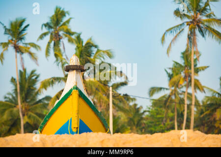 Vue rapprochée de belle couleur et bateau en bois sur la plage. Palmiers dans l'arrière-plan. Varkala plage tropicale, Kerala, Inde. Banque D'Images