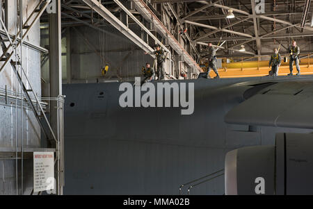 U.s. Air Force Airmen entrez une berline haut de la côté d'un C-5M Super Galaxy garée dans un hangar pour l'entretien, 22 septembre 2017, Travis Air Force Base, en Californie de la maintenance du 660 e Escadron de maintenance des aéronefs sont responsables de la sécurité et la fiabilité de l'leet, renforçant ainsi la puissance aérienne américaine à travers le monde.(U.S. Air Force photo de Heide Table) Banque D'Images