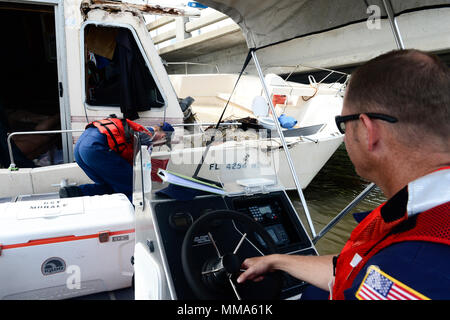 L'équipage de la Garde côtière canadienne avec les Florida Keys de la Direction générale de la fonction de soutien en cas d'urgence 10 Floride place une évaluation autocollant sur la coque d'un navire de personnes déplacées par le cyclone Irma dans Boot Key Harbour, près de Marathon, en Floride, le 29 septembre, 2017. Plus d'information est disponible pour les propriétaires de navire intéressé par la suppression de leur bateau à http://myfwc.com/boating/vessel-hotline/removal/. U.S. Coast Guard photo de Maître de 2e classe David Weydert. Banque D'Images