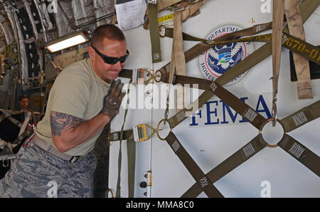 Vechinsky Senior Airman Chris, une antenne porter à partir de Westover Air Reserve Base, Mass., les positions d'un générateur sur un C-17 Globemaster III à Dobbins Air Reserve Base, Ga., Octobre 1, 2017. Air Force et l'Agence fédérale de gestion des urgences d'aéronefs sous contrat continuent à arriver à Dobbins pour ramasser de l'équipement médical et de l'infrastructure, et les fournitures de secours. (U.S. Air Force photo de Tech. Le Sgt. Kelly Goonan/libérés) Banque D'Images