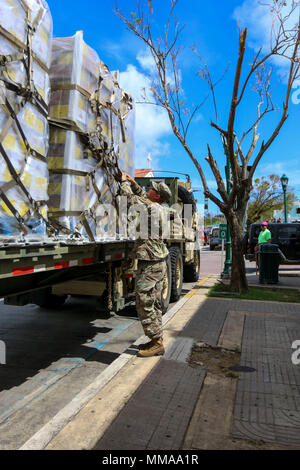 Le Sgt. Crew Gill, un agent de la police militaire affecté à la 3ème commande soutien expéditionnaire, unhooks une palette de net autour de repas prêts-à-manger, 2 octobre 2017, dans l'île de Porto Rico Vieques. La priorité absolue du Ministère de la défense, de travailler ensemble à l'appui de l'Agence fédérale de gestion des urgences, et les autorités locales à Porto Rico est de fournir les moyens de sauvetage et au maintien de la vie, à ceux qui sont dans les zones touchées. (U.S. Photo de l'armée par le Sgt. 1re classe Donna Davis) Banque D'Images