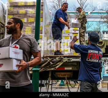 Le Sgt. Crew Gill, un agent de la police militaire affecté à la 3ème commande soutien expéditionnaire, les pompiers du service des incendies de la ville de New York, et une croix rouge aide télécharger les repas prêts-à-manger, d'un scanner à plat militaire le 2 octobre 2017, à Vieques. La priorité absolue du Ministère de la défense, de travailler ensemble à l'appui de l'Agence fédérale de gestion des urgences, et les autorités locales à Porto Rico est de fournir les moyens de sauvetage et au maintien de la vie, à ceux qui sont dans les zones touchées. (U.S. Photo de l'armée par le Sgt. 1re classe Donna Davis) Banque D'Images