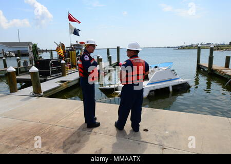 Edward Primeau et le Premier maître de Forte riche, à la fois de l'équipe de choc de l'Atlantique discuter les opérations de dépose pour un navire partiellement submergé à Rockport, Aransas Marina, au Texas, le 29 septembre, 2017. La Garde côtière a travaillé avec l'Office des terres et au Texas pour supprimer des entrepreneurs déplacées ou partiellement immergé navires après l'ouragan Harvey. U.S. Coast Guard photo de Maître de 3e classe Valerie Higdon. Banque D'Images