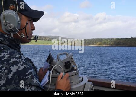 170929-N-FP878-026 Faslane (Écosse) (sept. 29, 2017) Spécialiste des questions de personnel 2e classe Candelario Contreras, de Cedar Park, Texas, monte la garde à bord de la classe Arleigh Burke destroyer lance-missiles USS Donald Cook (DDG 75) que le navire arrive à Faslane, en Écosse, pour un service au port le 29 septembre, 2017. Donald Cook, l'avant-déployé à Rota, en Espagne, est sur sa sixième patrouille dans la sixième flotte américaine zone d'opérations à l'appui des alliés et partenaires, et les intérêts de sécurité nationale des États-Unis en Europe. (U.S. Photo par marine Spécialiste de la communication de masse 1re classe Theron J. Godbold /Publié Banque D'Images