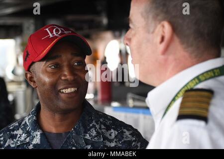 170929-N-FP878-017 Faslane (Écosse) (sept. 29, 2017) Le Cmdr. Timothy Moore, commandant de la classe Arleigh Burke destroyer lance-missiles USS Donald Cook (DDG 75), parle avec le pilote écossais que le navire arrive à Faslane, en Écosse, pour un service au port le 29 septembre, 2017. Donald Cook, l'avant-déployé à Rota, en Espagne, est sur sa sixième patrouille dans la sixième flotte américaine zone d'opérations à l'appui des alliés et partenaires, et les intérêts de sécurité nationale des États-Unis en Europe. (U.S. Photo par marine Spécialiste de la communication de masse 1re classe Theron J. Godbold /libéré) Banque D'Images