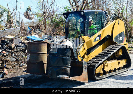 Une des matières dangereuses-déménagement engagée par l'Agence de protection de l'dirige le supprime de barils et contenants de personnes déplacées par le cyclone Irma à Big Pine Key, en Floride, le 3 octobre 2017. Les équipes de terrain de l'EPA, dirigé par les coordonnateurs sur place, sont de faciliter les évaluations fondées sur des terres et des actions de réponse en coordination avec le commandement unifié de la fonction de soutien en cas d'urgence 10 en Floride. U.S. Coast Guard photo de Maître de 2e classe David Weydert. Banque D'Images