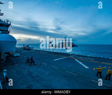 171003-N-JW440-0068 MER DES CARAÏBES (oct. 03, 2017) le signal des marins l'atterrissage d'un MH-60S Sea Hawk comme le navire d'assaut amphibie USS Wasp LHD (1) le transit de la mer des Caraïbes à l'appui des efforts de secours à Porto Rico. Le Wasp est d'aider aux secours après le passage de l'Ouragan Maria. Le ministère de la Défense soutient l'Agence fédérale de gestion des urgences, le principal organisme fédéral, en aidant les personnes touchées par l'Ouragan Maria afin de minimiser la souffrance et est une composante de l'ensemble de l'intervention. (U.S. Photo de la marine par la communication de masse Specialis Banque D'Images