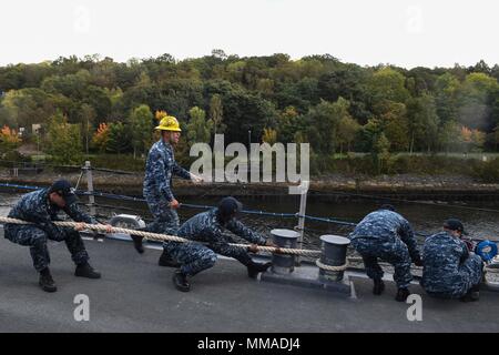 170929-N-FP878-056 Faslane (Écosse) (sept. 29, 2017) le soulèvement des marins à bord de la ligne de classe Arleigh Burke destroyer lance-missiles USS Donald Cook (DDG 75) que le navire arrive à Faslane, en Écosse, pour une visite du port. Donald Cook est l'avant-déployé à Rota, Espagne, sur sa sixième patrouille dans la sixième flotte américaine zone d'opérations à l'appui des alliés et partenaires, et les intérêts de sécurité nationale des États-Unis en Europe. (U.S. Photo par marine Spécialiste de la communication de masse 1re classe Theron J. Godbold/libérés) Banque D'Images