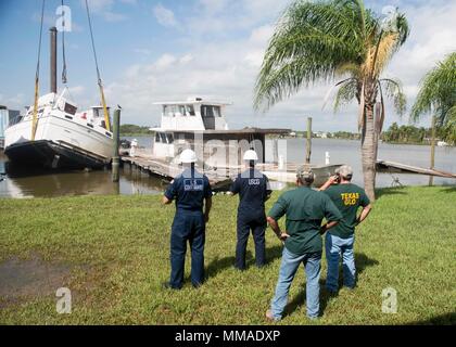 Des représentants de la Garde côtière et le Texas Land Office général de surveiller la récupération d'un cabin cruiser engloutie par Laredo Construction à Dickinson Bayou le 4 octobre 2017. La Garde côtière et TGLO travaillent avec d'autres organismes fédéraux, d'état et agences tribales pour coordonner les efforts de rétablissement à la suite de l'ouragan Harvey. Photo de la Garde côtière des États-Unis par le Premier maître de Jean Masson. Banque D'Images