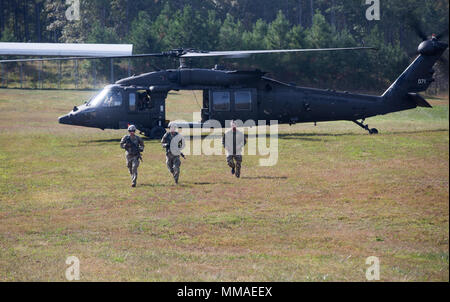 Le sergent de l'armée américaine. Grant Reimers, gauche, le s.. Daniel Brita, milieu, affecté à la Garde nationale de l'armée américaine, et un meilleur cadre guerrier états quitte un UH-60 Blackhawk hélicoptère vers leur prochain objectif pendant le meilleur guerrier Competetion à Fort A.P. Hill, en Virginie, le 5 octobre 2017. La Convention est un programme annuel d'une semaine que l'événement va tester 22 soldats à partir de 11 grandes commandes sur leurs capacités physiques et mentales. (U.S. Photo de l'armée par la CPS. Jada Owens) Banque D'Images