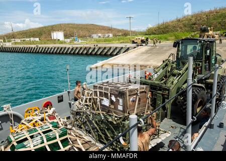 Les Marines américains et les marins de la marine avec la 26e Marine Expeditionary Unit (MEU), de charger l'équipement et des fournitures dans une barge de débarquement, l'utilité d'être utilisé pour le suivi sur l'appui aux victimes de l'Ouragan Maria Fajardo, Porto Rico, 5 octobre 2017. La 26e MEU soutient l'Agence fédérale de gestion des urgences, le principal organisme fédéral, en aidant les personnes touchées par l'Ouragan Maria à Porto Rico afin de minimiser la souffrance et est une composante de l'ensemble de l'intervention. (U.S. Marine Corps photo par Lance Cpl. Tojyea G. Matally) Banque D'Images