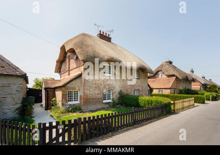 Brique rouge attrayant de style local thatched cottage / cottages en Orient Stratton, un petit village près de Winchester, dans le Hampshire, dans le sud de l'Angleterre Banque D'Images