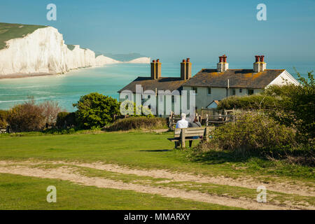 Au début du printemps, garde-côtes Cottages East Sussex. Sept Sœurs falaises au loin. Banque D'Images