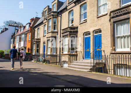 Cambridge, UK -Avril 2018.Couple de derrière la marche dans une résidence typique de la rue avec des maisons victoriennes Anglais classique avec des portes dans un endroit ensoleillé Banque D'Images