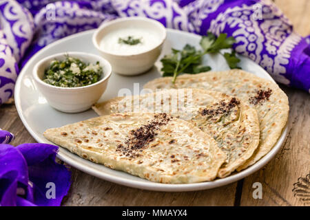 Cuisine traditionnelle d'Azerbaïdjan. Capture d qutabs horizontal -pain plat avec les verts. Servi avec du yogourt dans la plaque en céramique blanche. Banque D'Images