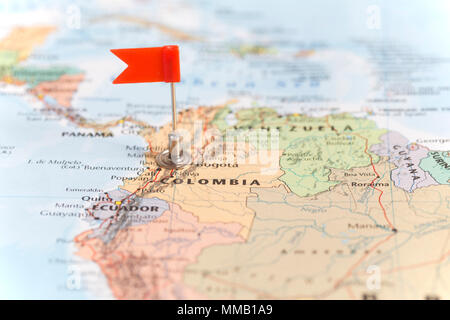 Petit drapeau rouge marquant le pays sud-américain de la Colombie sur une carte du monde. Banque D'Images