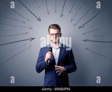 Businessman parlant au micro avec des flèches pointant vers la tête Banque D'Images