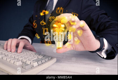 Un bureau commercial promouvoir ses idées de concept avec l'illustration des médias en ligne et les logos de l'appareil autour de l'ampoule en verre électrique. Banque D'Images