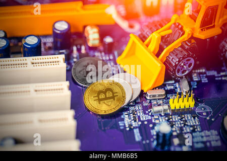 Concept : Bitcoin mining machine Miniature Pelleteuses creuser travailleur mineur pièce précieuse d'or sur la carte de circuits électroniques Banque D'Images