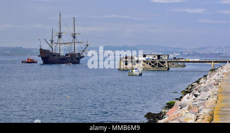 El Galeon andalousie passant l'ancienne jetée de carburant le long du brise-lames à Brixham dans le Devon, d'être escorté dans l'eau libre par le bateau-pilote local. Banque D'Images