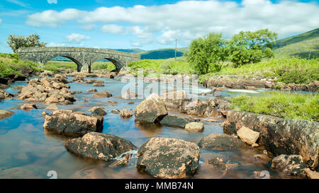 Low angle shot d'un vieux pont enjambant une rivière vers Loch Scridain l'île de Mull en Écosse Banque D'Images